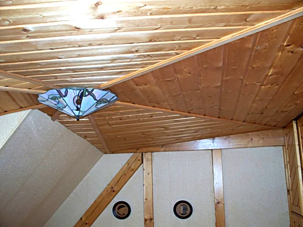 Holzverkleidete Dachschräge mit Leuchte